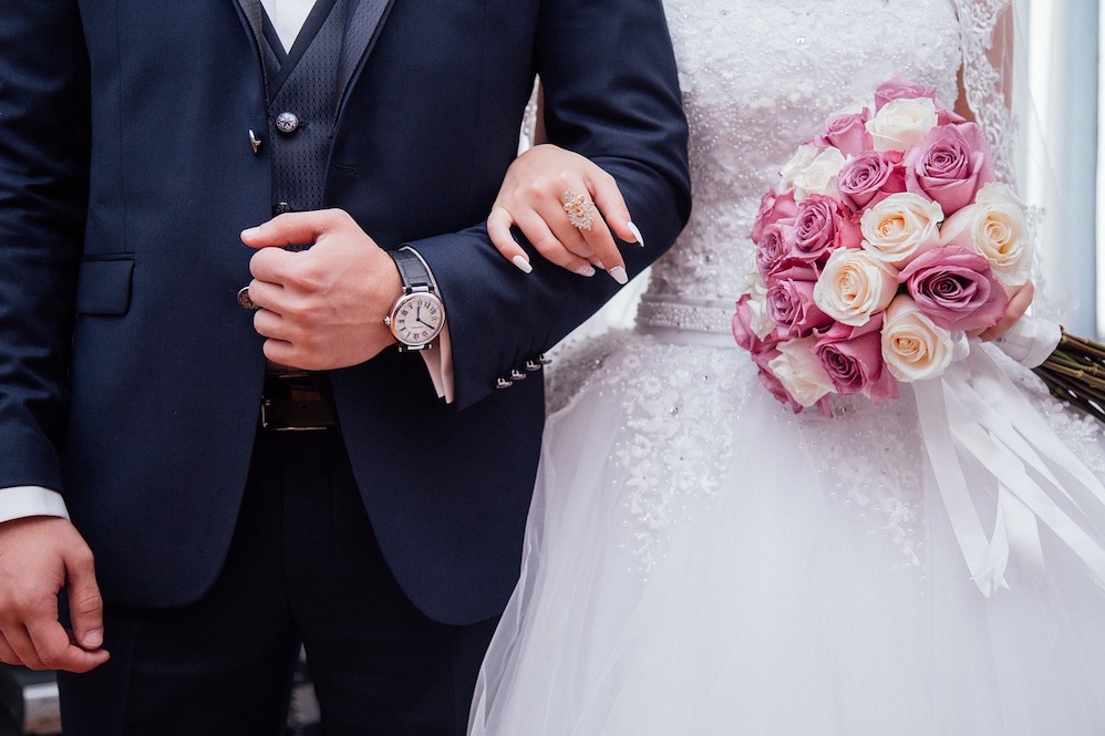 結婚式でウェディングドレスを着る女性とスーツを着る男性